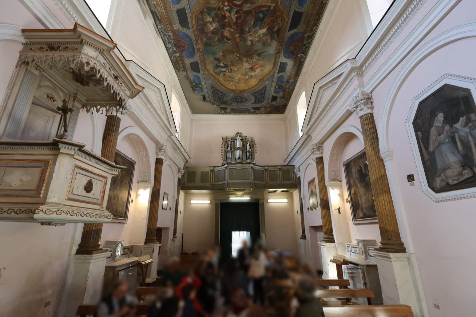 La navata vista verso l'ingresso, con la cantoria dell'organo e la tela del soffitto